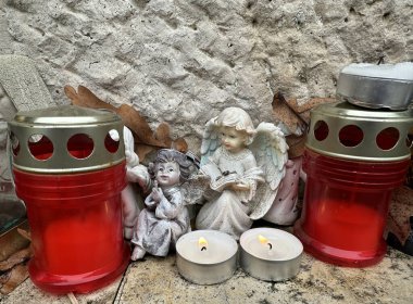 Halk mezarlığındaki bir mezar taşında fenerler ve melek figürleri.