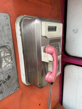 Telefon kulübesinde mahvolmuş eski bir telefon.