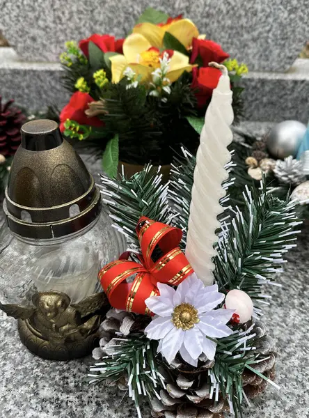 Wreath and candle on the tombstone in the public cemetery