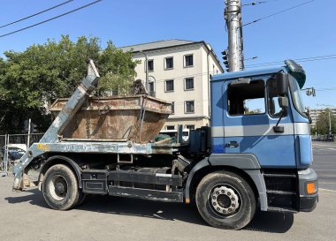 Büyük bir endüstriyel çöp tenekesi olan bir kamyon.