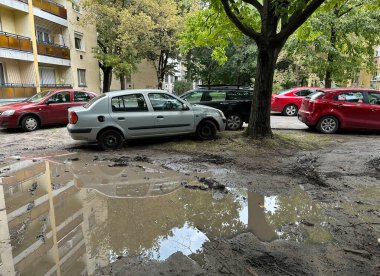 Arabalar çamurlu otoparkta duruyor.