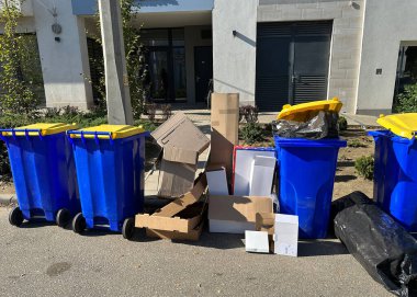 Caddedeki çöp tenekeleri binanın önünde.