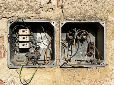 Eski bir evin duvarında kırık bir elektrik düğmesi.