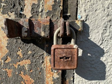Eski paslı asma kilit duvarda.