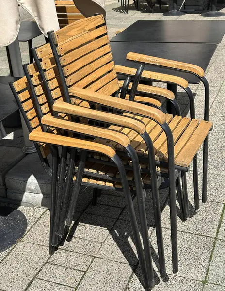 Tahta sandalyeler caddeye dizilmiş.
