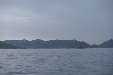 Bulutlu bir günde deniz ve dağlar silüet, Mavi Deniz ve dağların gölgesi, boş huzurlu kuzey manzarası