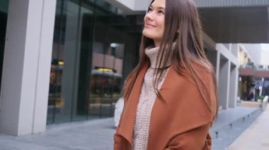 Genç, güzel, gülümseyen bir kadın şehirde dolanıyor ve kendine güvenen bir iş kadını turist sonbahar resmi hayal ediyor.