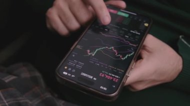 Akıllı telefonu borsa grafiğiyle kapat, dokunmatik ekranda elleri kaydırmalı, borsa verilerini kontrol et, seçici odaklanma