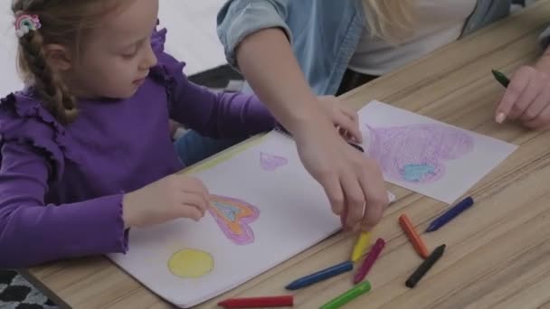 絵を学び 異なる色の鉛筆とクレヨンと彼女の母親と娘に絵を描く方法を示すのを助ける子供の女の子のビューを閉じます — ストック動画