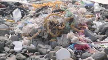 scene of plastic waste on the beach and a pile of garbage, illustrating the catastrophic impact of human activity on the environment. 