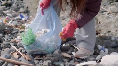 Çevre koruma kavramı. Genç gönüllü çöp plastiği ve kağıt atık şişelerini temizliyor. ekoloji kirliliği sorunu