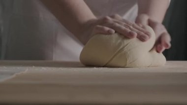 close up of dough, flour and cook hands with flour splash, bread dough with white powdered table. concept fresh homemade cooking