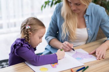 Kızlar sınıfta öğretmenleriyle oturuyor ve resim ve çizim öğreniyor. Sanat terapisi veya çocuk resim okulları ve yaratıcılık gelişimi için resim dersleri alıyor.