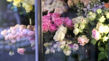 Çiçekçilerin buzdolabı odası, çeşitli taze bahar çiçekleri, çiçekçi dükkanının cam kapısının arkasındaki buketler.. 