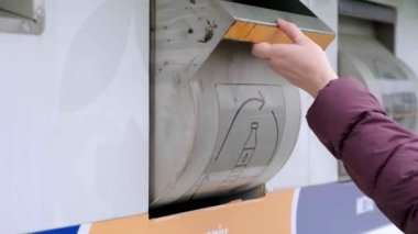 Bir kadın plastiği geri dönüşüm kutusuna, çöp ayıklama konseptine, farklı çöp kutusuna atık ayıklama konseptine atarken, gerçek atık yönetimi iş başında.