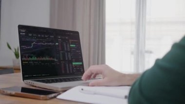 Borsada kripto ticareti için dizüstü bilgisayar başvurusu yapan genç bir finans analisti. Yatırım aracılığı ticaret kavramı.