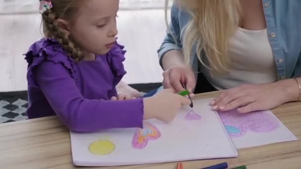 子供のための創造力育成趣味 居心地の良いリビングルームの母と娘母と娘はカラフルな鉛筆とクレヨンで絵を描き — ストック動画