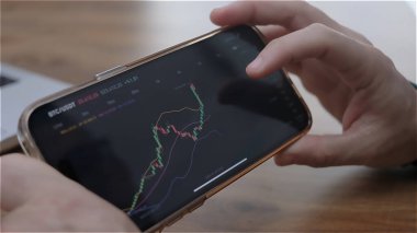 Yeşil ve kırmızı şamdanların yükseldiği borsa grafiği kriptonun arttığını gösteriyor. Şifreleme para birimi fiyat geçmişinin ses ve zaman aralıklarını gösteren ticaret uygulaması