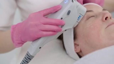 Güzellik merkezi, yetişkin bir kadın müşteriye profesyonel ekipmanlarla ultrason masajı yaptırmak için huzurlu bir ortam sunuyor.. 