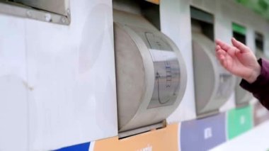 Kadın plastik atıkları atıyor çöp kutusuna atıyor, sokakta duruyor. sorumlu vatandaş atık yönetimi yapıyor.