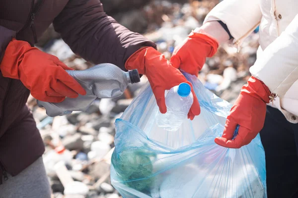 stock image close up woman hands wearing gloves collecting plastic garbage to help clean up beach and public park to protect environment from pollution