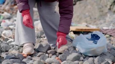 Plajdan ya da parktan bir kadın tarafından toplanan plastik atık dolu çöp torbasını kapat. Kirlilikten korumak ve kamu alanlarını temizlemek.