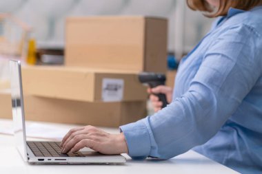 Bilgisayardaki çevrimiçi kontrol siparişlerini paketleyip kargo için karton kutulara doldurun, barkodları kontrol edin