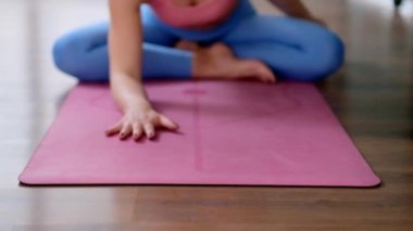 Profesyonel yoga sınıfında vücut ve zihin rahatlığı için meditasyon yapan kız öğrenci. Genç bir kadın kameraya doğru eğiliyor.