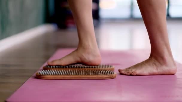 在宽敞的演播室里 赤脚站着做指甲反射治疗的女性专业瑜伽课上 在粉红垫子上的沙迪湖板上进行有效的身体放松练习 — 图库视频影像