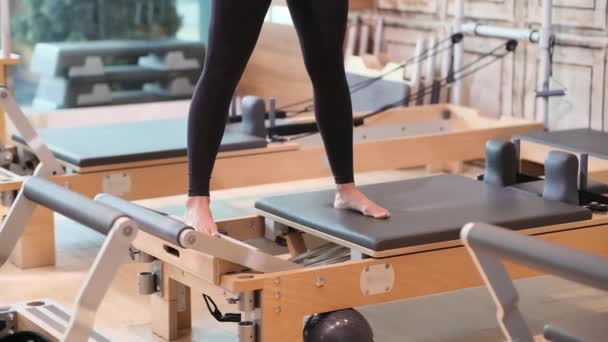 Professional Pilates Exercise Flexible Body Woman Stretching Legs Reformer Studio — Stock Video