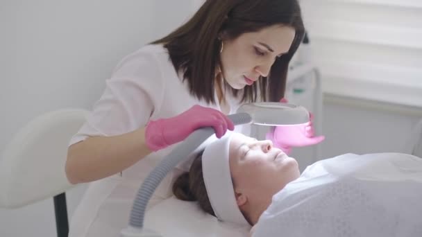 Wykwalifikowany Kosmetolog Bada Skórę Klienta Pomocą Lampy Powiększającej Fachowo Lecząc — Wideo stockowe