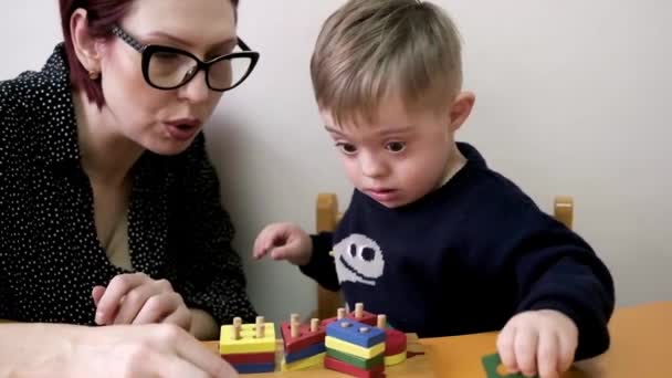 母親とダウン症候群の子供は教育ブロックで創造性を探求しリラックスした活動を一緒に楽しむ — ストック動画