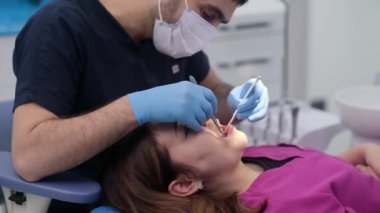 Hasta dişlerini incelemek için diş aletleri kullanan deneyimli bir dişçi tarafından sunulan yüksek kaliteli diş bakımı hizmetleri 