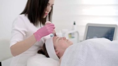 Ultrasonik temizleme ile yüz temizleme deneyimi. Yakın planda ultrason tedavisi klinikte profesyonel derin gözenek temizleme kozmetolojisti sağlar.