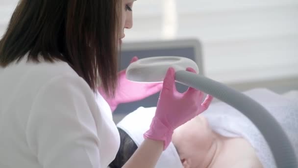 美容室で肌の健康や美容室でのコンサルティング 拡大ランプで肌を検査して個別化治療を提供する美容専門家 — ストック動画