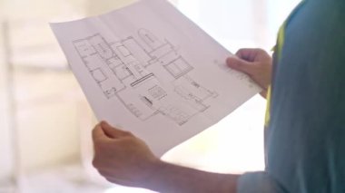 Profesyonel mimar, inşaat güvenlik ekipmanlarının yenilenmesinde çalışan üniforma uzmanı merdiven uzmanına karşı el ele duran parmak daire çizim kağıtlarını işaret ediyor.