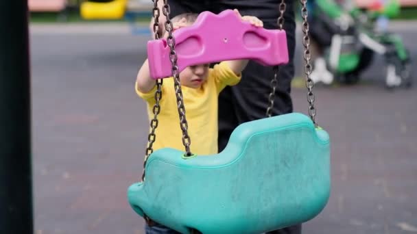 Цікава Дитина Синдромом Дауна Вивчає Деталі Ланцюгових Гойдалок Стоять Поруч — стокове відео