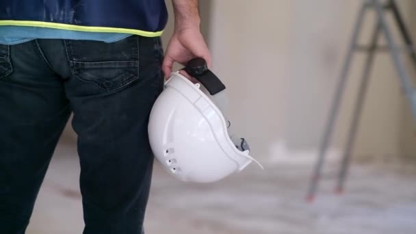 工事現場の安全規則及び改修工程中の設備に立ち会う白い保護用の硬い帽子を手に持った制服を着た熟練労働者 — ストック動画