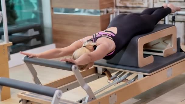 Pilates Practicing Modern Gym Fit Blonde Coach Lying Reformer Stretching — Stock Video