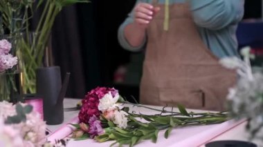 Çiçekçi kadın düğün için çiçek dizayn eder, dekoratör doğum günleri ve partiler için çiçek hazırlar..