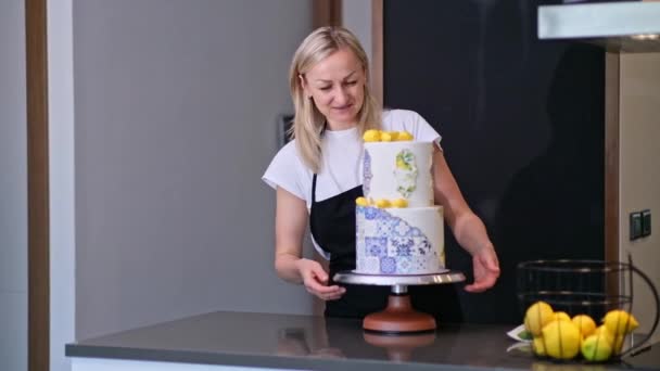 Szczęśliwa Kobieta Cukiernik Patrząc Gotowy Tort Weselny Ozdobiony Żółtymi Cytrynami — Wideo stockowe