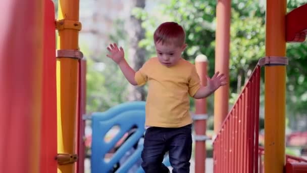 Adorable Niño Soleado Camiseta Amarilla Caminando Sobre Colorido Escalador Agitando — Vídeo de stock