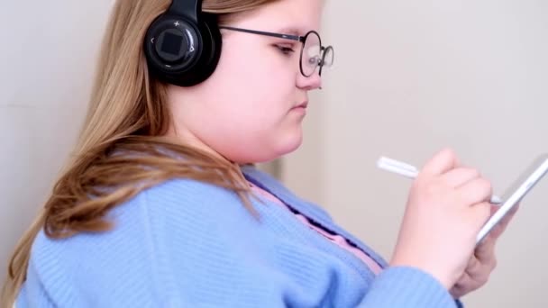 Soustředěná Dospívající Dívka Sluchátkách Dělá Kreativní Cvičení Tabletu Pomocí Speciální — Stock video