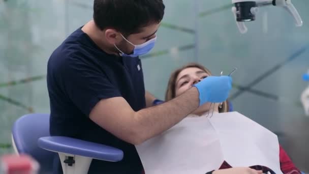 Zahnklinik Konzentrierte Zahnarzt Schutzmaske Überprüfung Zähne Der Jungen Patientin Termin — Stockvideo