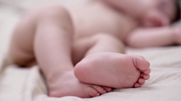 赤脚小男孩赤着脚躺在柔软的床上 躺在育婴室里 小宝宝醒来后 舒舒服服地躺在家里 — 图库视频影像