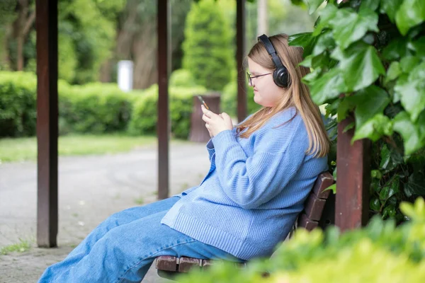 Blondynka Nastolatek Słuchawkach Słucha Muzyki Podczas Pisania Wiadomości Znajomego Telefon — Zdjęcie stockowe