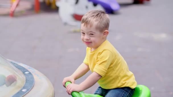 Niño Feliz Con Síndrome Disfrutando Montando Balancín Parque Infantil Habitual — Vídeos de Stock