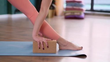 Mantar blokları ile etkili yoga egzersizi sportif kadın paspasın üzerinde duruyor spor giyim bölümünde aktif kadın stüdyoda sağlıklı yaşam tarzı profesyonel eğitimini sürdürüyor.