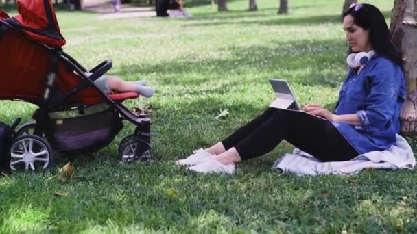 Small Feet Infant Baby Dreaming Stroller Mother Earphones Working Online — Stock Video