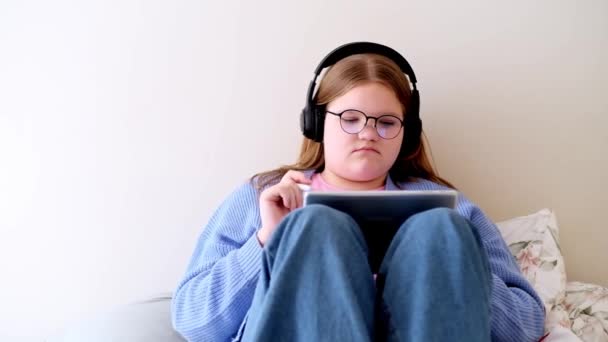 Χαλαρός Έφηβος Κορίτσι Ακουστικά Που Ολοκληρώνουν Online Εργασίες Στην Ιστοσελίδα — Αρχείο Βίντεο